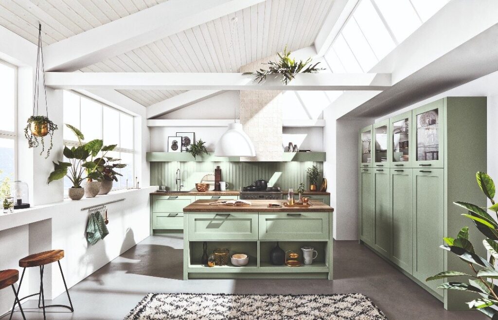 Green L-shaped kitchen with island and skylights