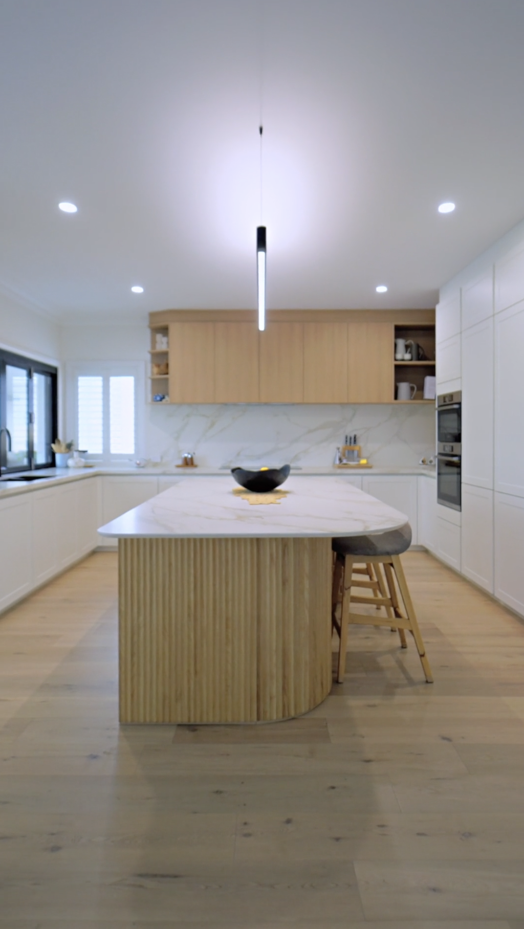 Custom Häcker luxury kitchen with matte white finishes, marble, and premium oak timber fluted cabinetry.